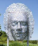 This contemporary wall sculpture of a mask is made out of metal. Image 3