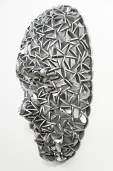 Forged from metal, this contemporary wall sculpture in a mask form is by Dale Dunning.