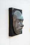 This contemporary figurative wall sculpture is a mask forged from metal lit with LED light. Image 4