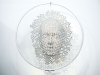 A patchwork of chrome powdercoated machine screws becomes an ethereal mask in this indoor sculpture by Dale Dunning. Image 2