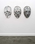 Narrow strips of aluminum are skillfully shaped in to the curves and folds of three masks in this triptych by sculptor Dale Dunning. Image 2