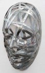Narrow strips of aluminum are skillfully shaped in to the curves and folds of three masks in this triptych by sculptor Dale Dunning. Image 4