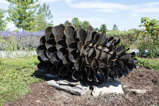 This contemporary outdoor steel sculpture of a pine cone by Floyd Elzinga is also wood-burning.