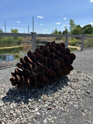 This contemporary outdoor steel sculpture of a pine cone by Floyd Elzinga is also wood-burning.