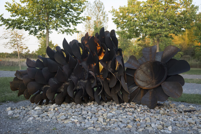 This contemporary outdoor steel sculpture of a pine cone by Floyd Elzinga is also wood-burning.