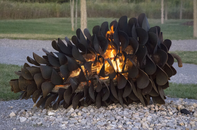 This contemporary outdoor steel sculpture of a pine cone by Floyd Elzinga is also wood-burning.