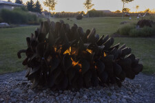 This contemporary outdoor steel sculpture of a pine cone by Floyd Elzinga is also wood-burning. Image 2