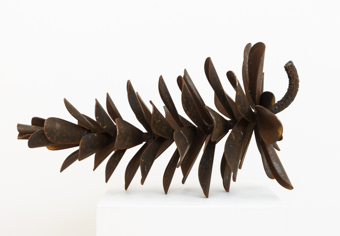 This contemporary table top steel sculpture of a pine cone is by Floyd Elzinga.