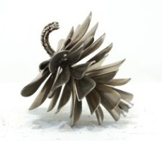 This contemporary table top metal sculpture of a pine cone is by Floyd Elzinga.