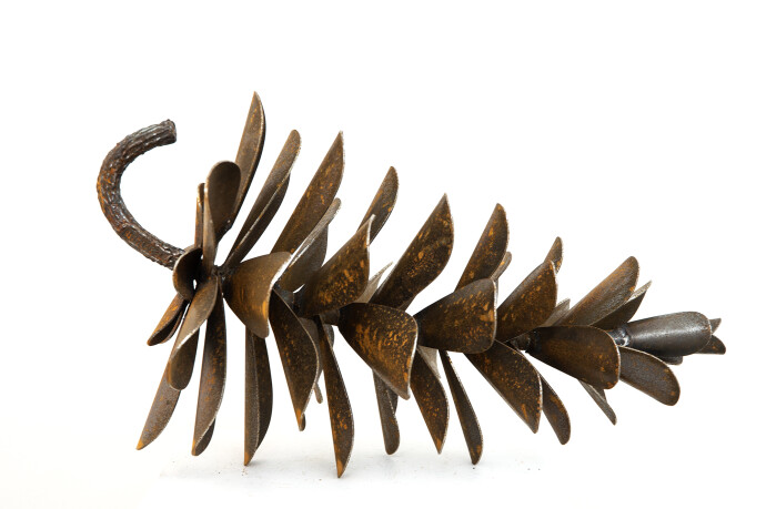 This contemporary table top steel sculpture of a pine cone is by Floyd Elzinga.