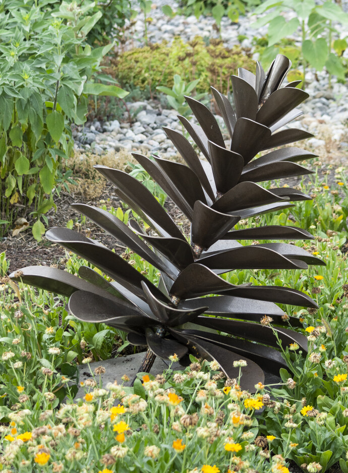 This contemporary outdoor sculpture of a pine cone is made from metal by Floyd Elzinga.