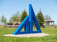 Two striking steel triangles painted in royal blue—in different sizes; their centers cut-out triangles stand beside one another in this new … Image 2