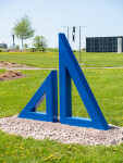 Two striking steel triangles painted in royal blue—in different sizes; their centers cut-out triangles stand beside one another in this new … Image 4