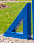 Two striking steel triangles painted in royal blue—in different sizes; their centers cut-out triangles stand beside one another in this new … Image 6