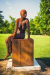 A seated female figure strikes a casual pose, body half turned in this imposing sculpture by American artist, Jason Kimes. Image 3