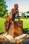 A seated female figure strikes a casual pose, body half turned in this imposing sculpture by American artist, Jason Kimes. Image 2