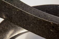 Smooth-surfaced, black granite flecked almost imperceptibly with copper and white has been engineered into an elegant ribbon in tangible con… Image 4