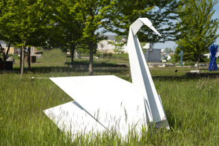 This contemporary metal garden sculpture is made in the form of a white swan.