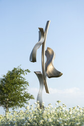 The highly polished stainless-steel reflects the sunlight; like ivy, three gently curved pieces ‘climb’ a central ‘branch’.