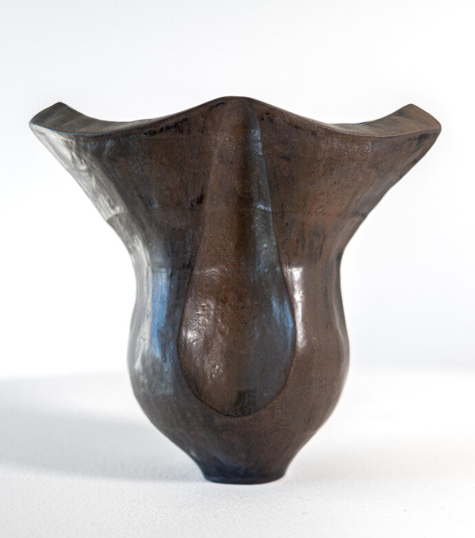 This contemporary ceramic black vessel in a floral shape is by Loren Kaplan.