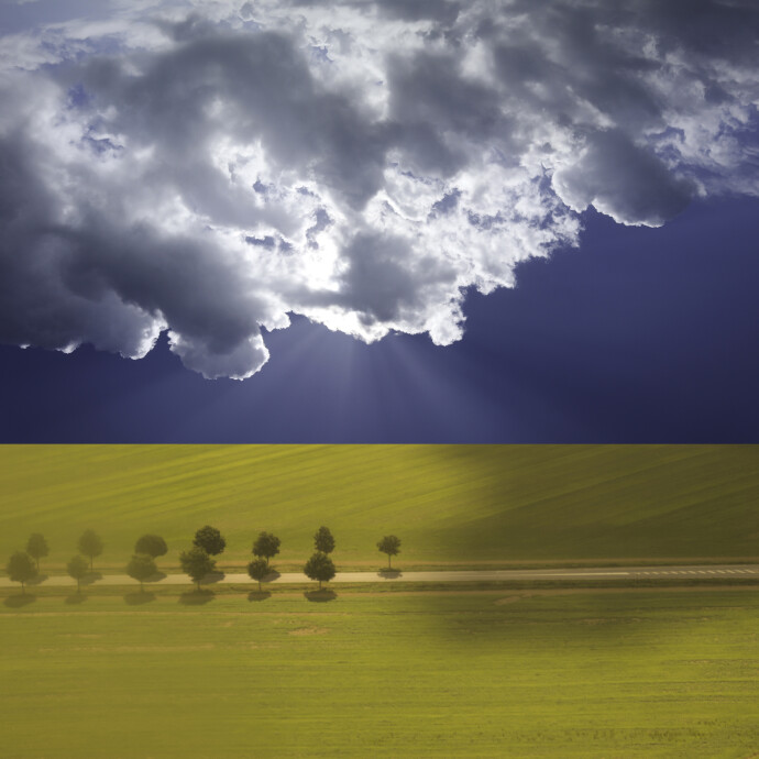 Clouds hover over a brilliantly lit, verdant green French landscape In his photo based artwork by Mark Bartkiw.