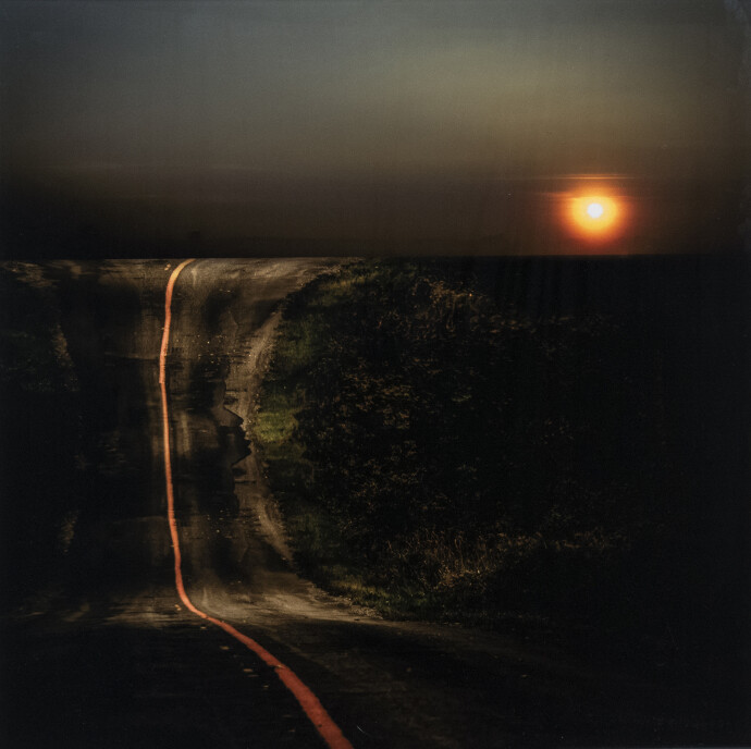 A line of fiery orange splits a dark road in two in this dramatic image by Mark Bartkiw.