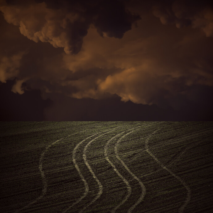 Unwinding tire tracks rise to meet a brooding sky in this dream-like image by Mark Bartkiw.