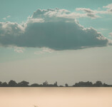 A large cloud in a teal sky hovers above a field of wheat in this surrealist inspired image by Mark Bartkiw. Image 3