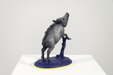 Cast in resin, a figurine of a boar posed on an indigo base points to a theme of human and animal interaction that includes taxidermy. Image 4