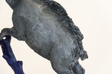 Cast in resin, a figurine of a boar posed on an indigo base points to a theme of human and animal interaction that includes taxidermy. Image 5