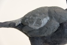 Cast in resin, a figurine of a pheasant posed on an indigo base points to a theme of human and animal interaction. Image 3
