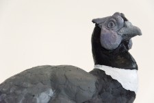 Cast in resin, a figurine of a pheasant posed on an indigo base points to a theme of human and animal interaction. Image 4