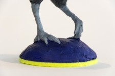 Cast in resin, a figurine of a pheasant posed on an indigo base points to a theme of human and animal interaction. Image 5