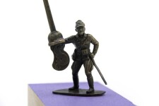 A military figure challenges an invisible foe with a latte stick in this playful bronze sculpture with wood base by P. Image 3