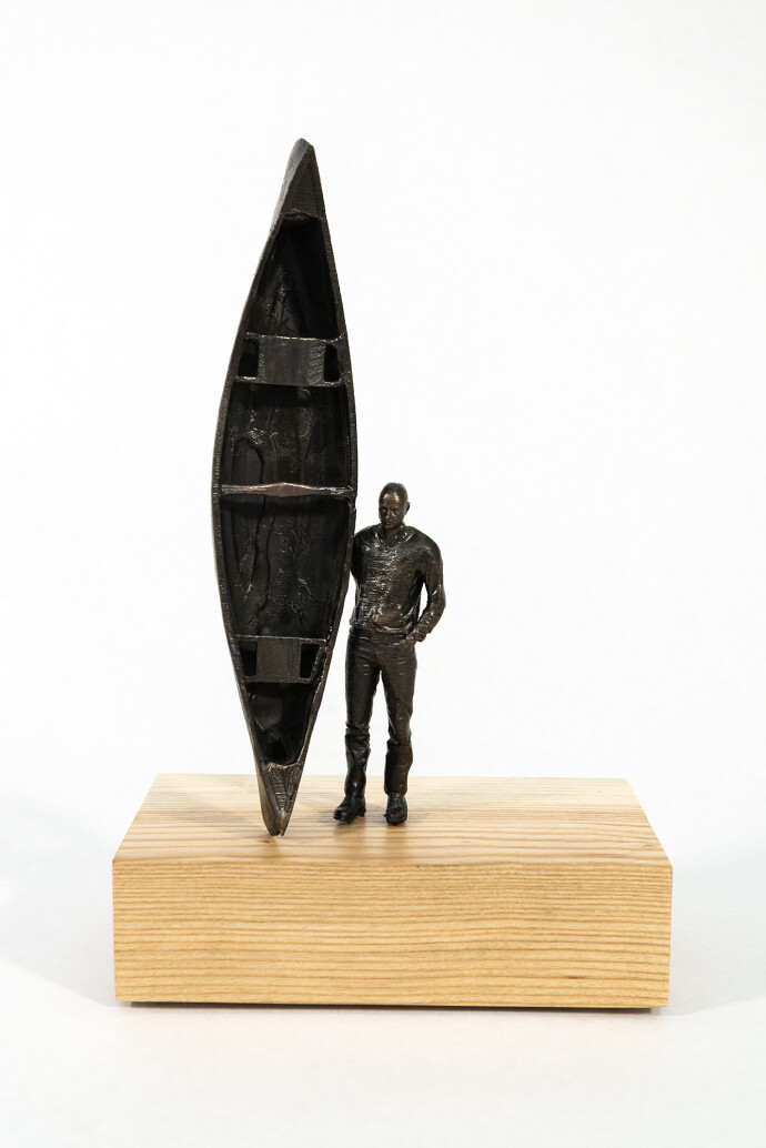 This bronze figurative tabletop sculpture by Roch Smith features a canoe.