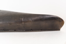 This indoor table top bronze sculpture features a man sitting on an overturned canoe. Image 8