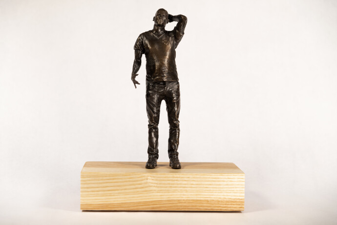 This bronze figurative table top sculpture by Roch Smith features a maple leaf.