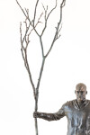 This indoor table top figurative sculpture of a male is cast in bronze. Image 7