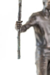This indoor table top figurative sculpture of a male is cast in bronze. Image 8