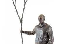 This indoor table top figurative sculpture of a male is cast in bronze. Image 5