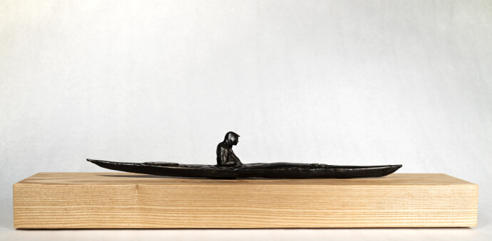 This figurative table top bronze sculpture of a kayaker is by Roch Smith.
