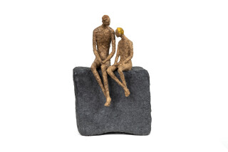 This contemporary figurative table top sculpture of a father and son is created from papier mâché.