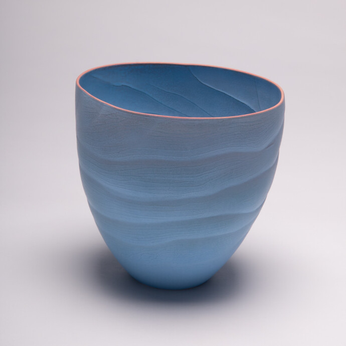 This contemporary blue ceramic vase has an organic shape inspired by nature.