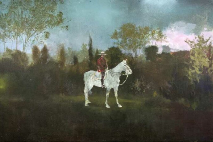 The iconic presence of a Mountie in red serge on a ghostly white horse is set against the epic backdrop of a forested landscape.