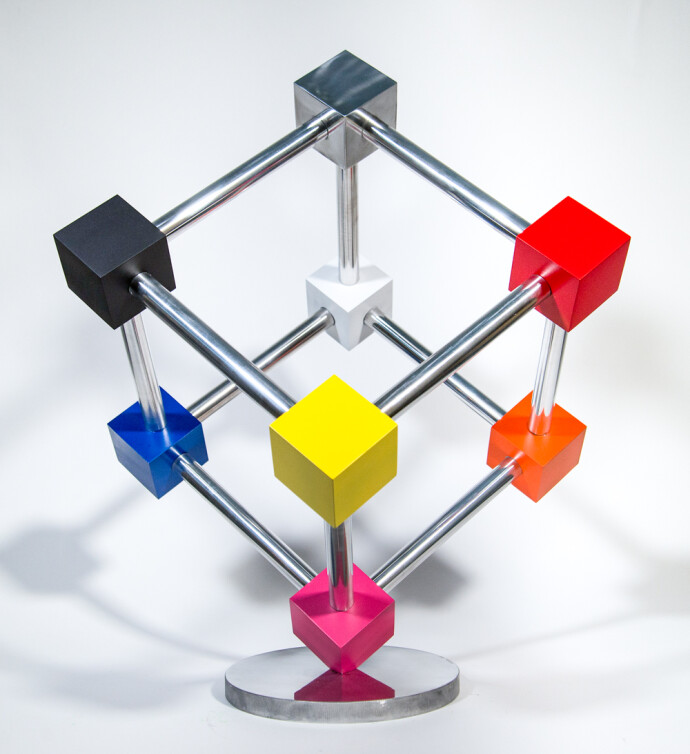 In this dynamic sculpture by Phillipe Pallafray, an open 3D stainless steel cube; each point connected by a brightly coloured solid cube in …