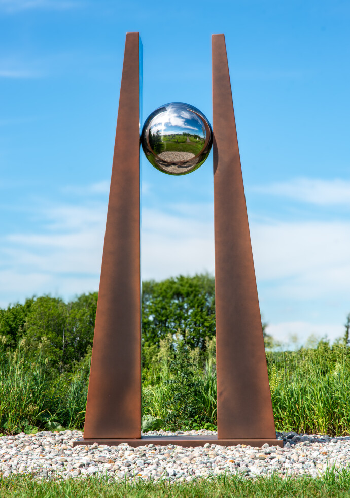 This contemporary outdoor architectural sculpture is forged from steel.