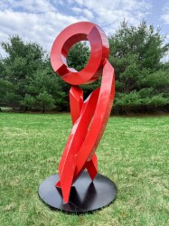 This large scale abstract metal sculpture in red painted metal is by Rob Lorenson.