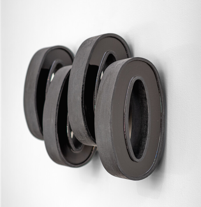 This contemporary wall sculpture by Rod Mireau is made of black wood and resin.