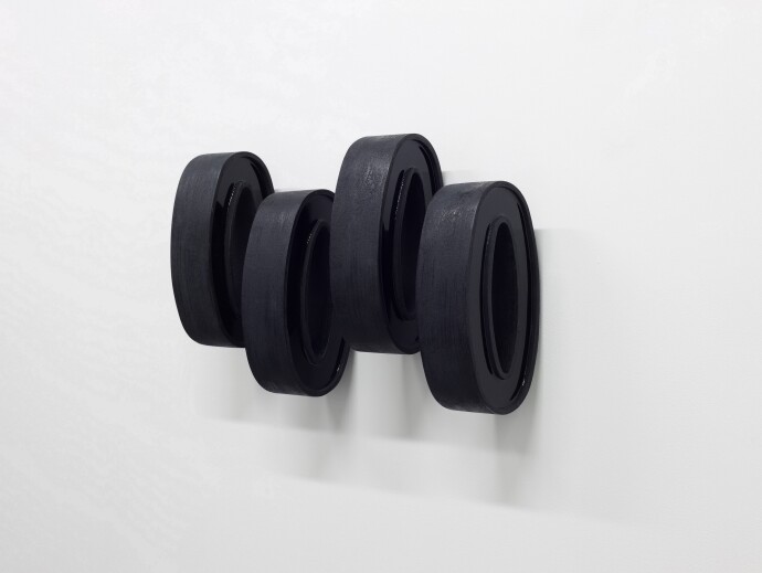 This contemporary wall sculpture by Rod Mireau is made of black wood and resin.