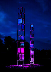 The striking metal towers of the Chroma series are stacked frames of glass that change colours and images as sunlight shines through them.